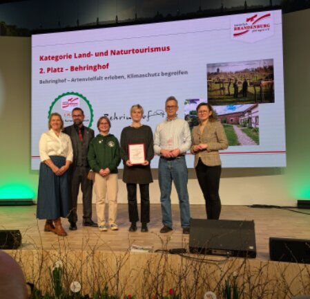 Familie auf dem Biohof mit Blick zur Scheune